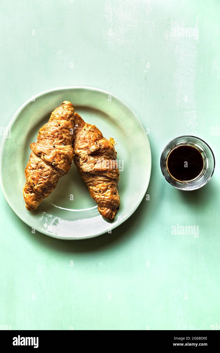 Buttery Croissant with a glass of Black Coffee Stock Photo