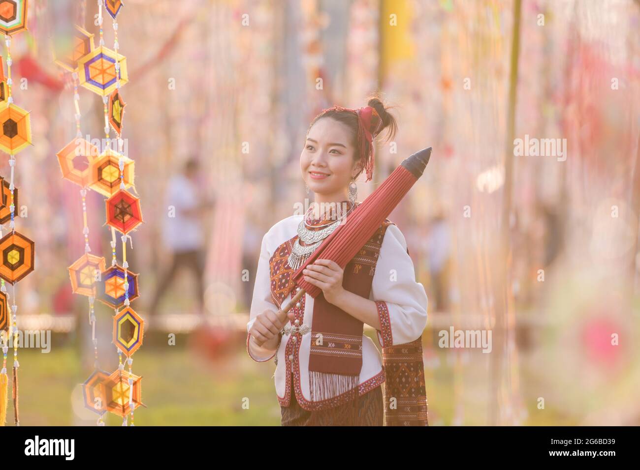 Portrait of a smiling woman in traditional Thai clothing holding a parasol, Thailand Stock Photo