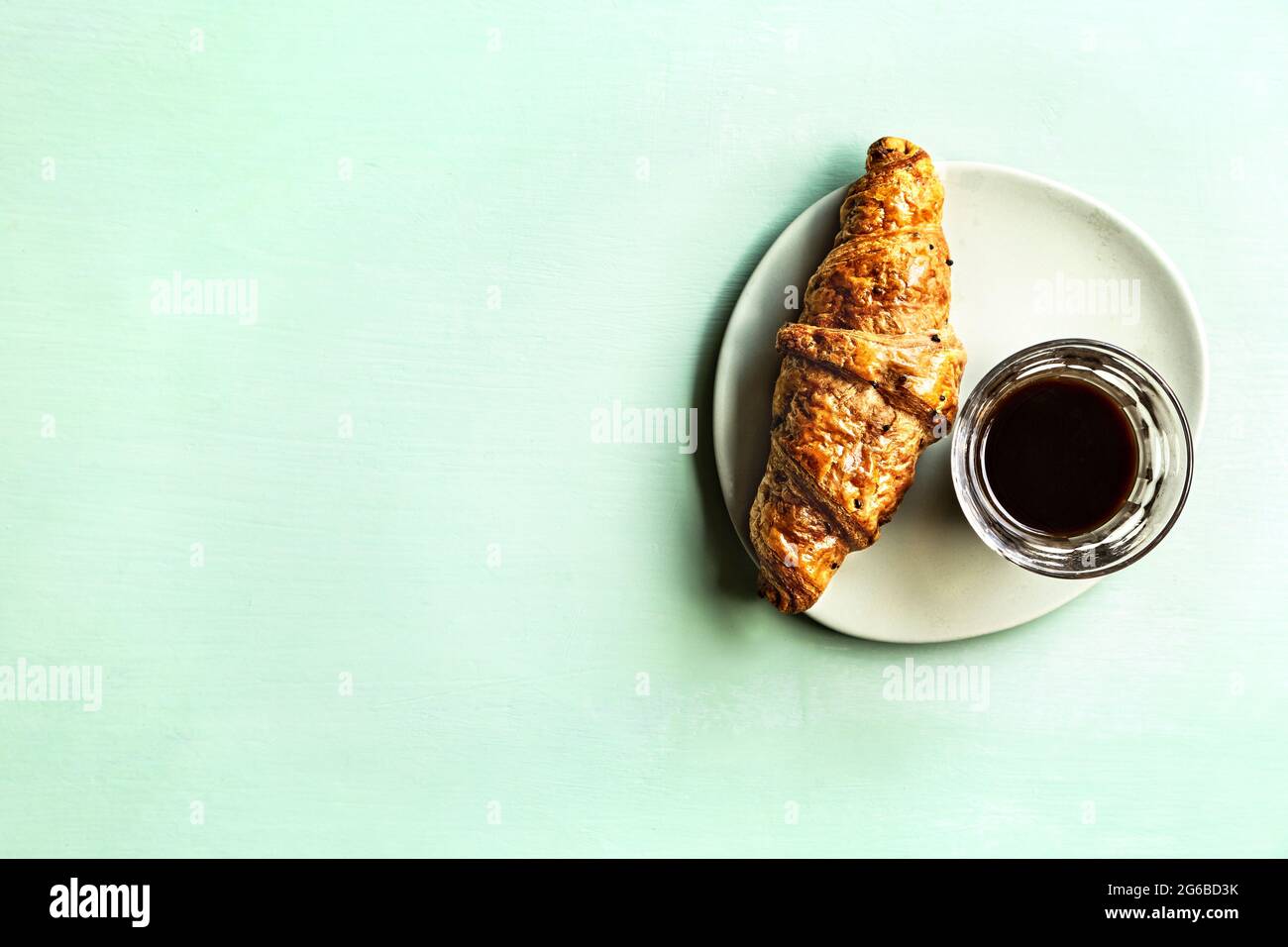 Buttery Croissant with a glass of Black Coffee Stock Photo