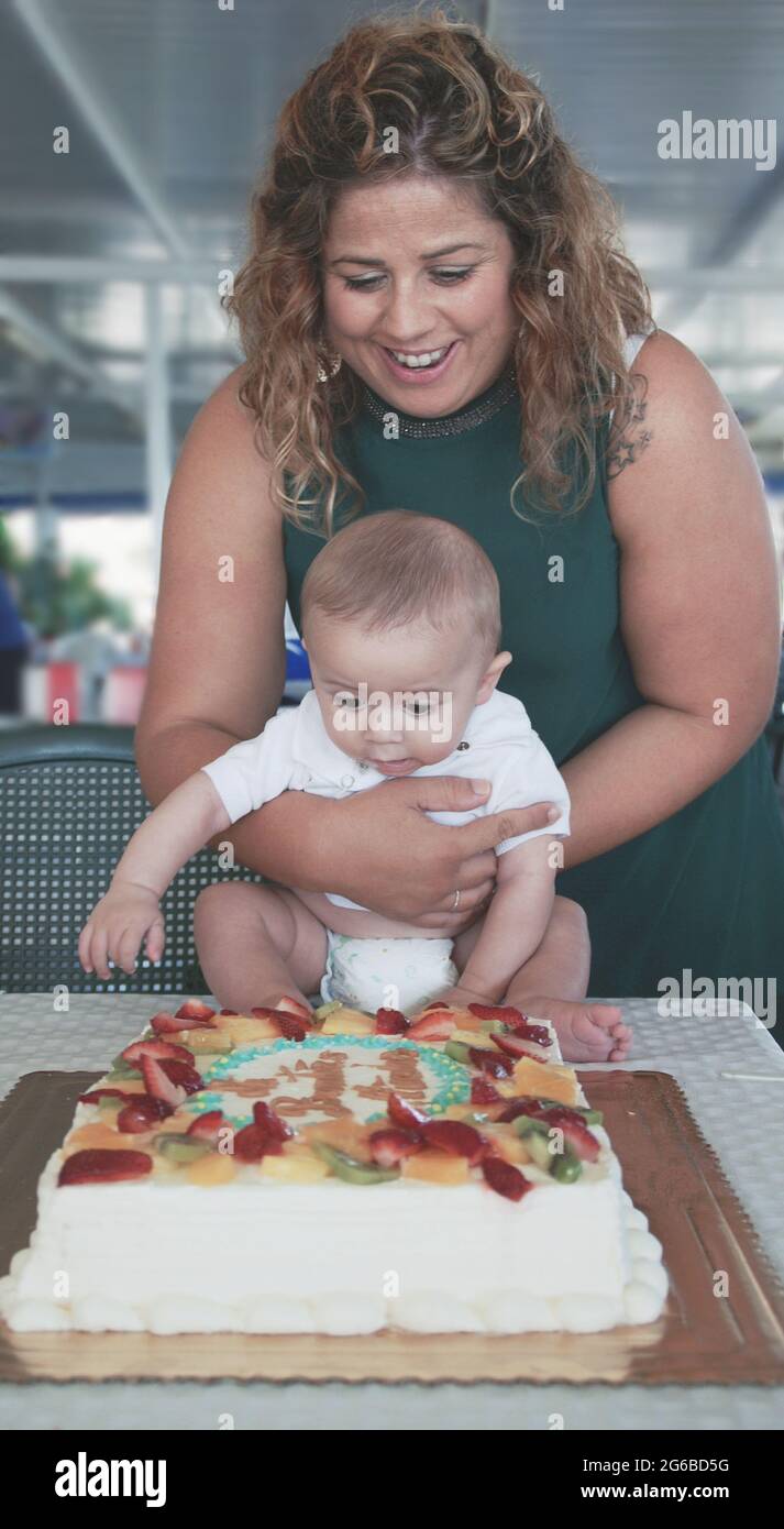 Mother standing in front of a first birthday cake with her son Stock Photo