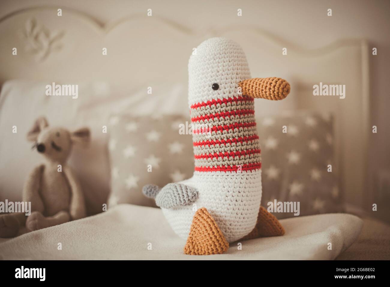 Amigurumi seagull sitting on a bed Stock Photo