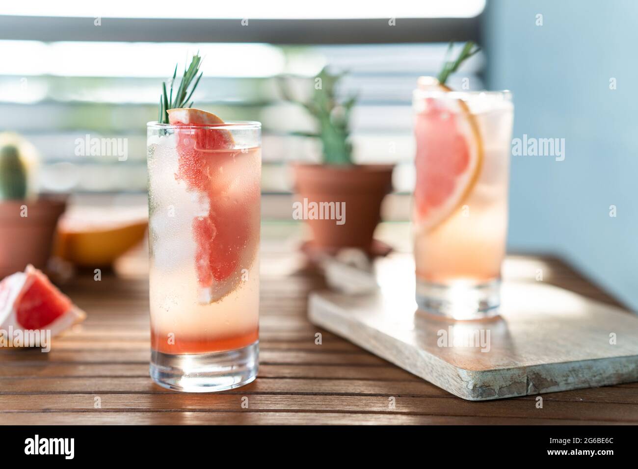 Two glasses of water with fresh grapefruit and grapefruit segments on a table Stock Photo