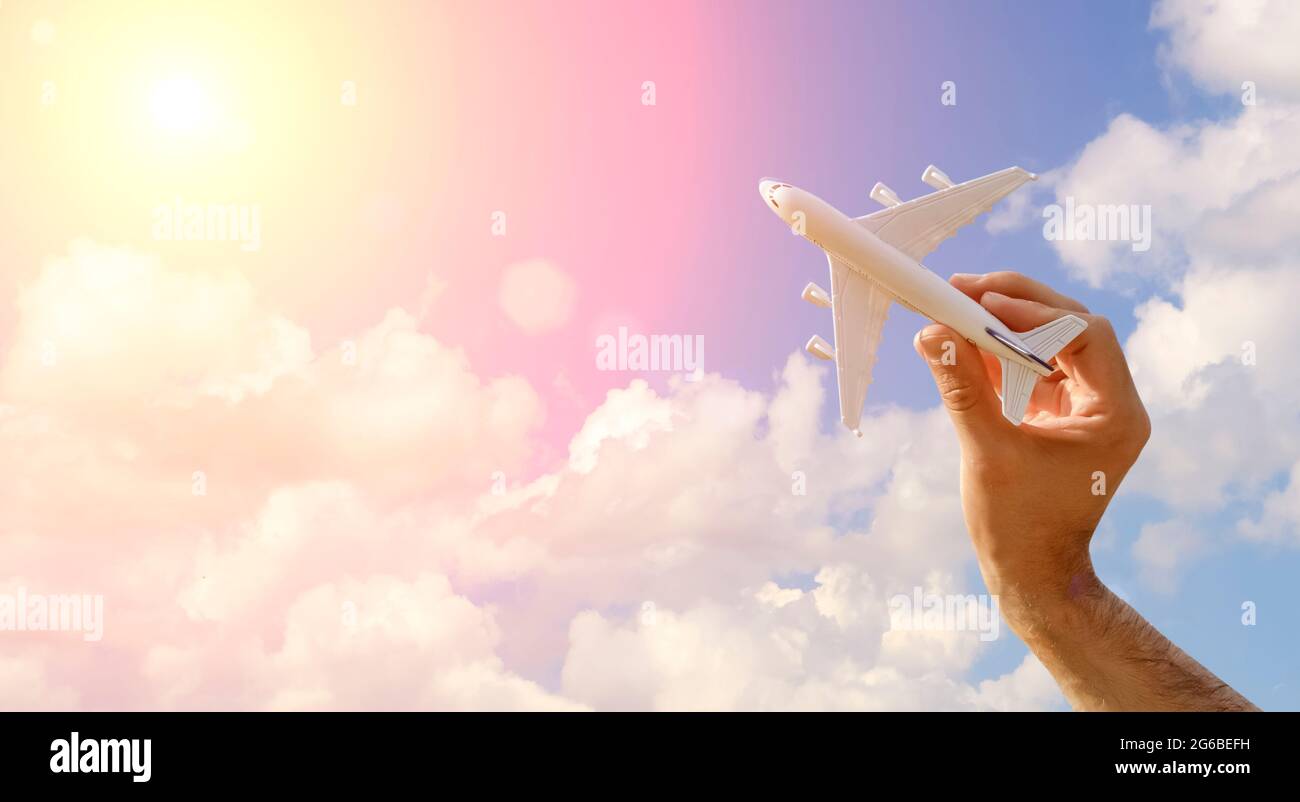 Flying plane on the blue sky banner background. A toy plane in hand flies  to travel. Summer, vacation, travel, relaxation, tours and flights concept.  High quality photo Stock Photo - Alamy
