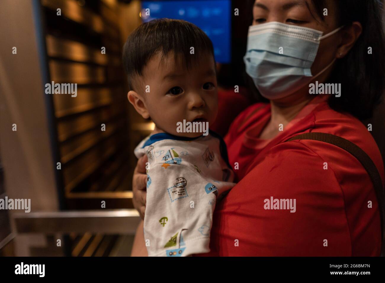 Cute and adorable Asian Chinese baby boy carry up by mother with
