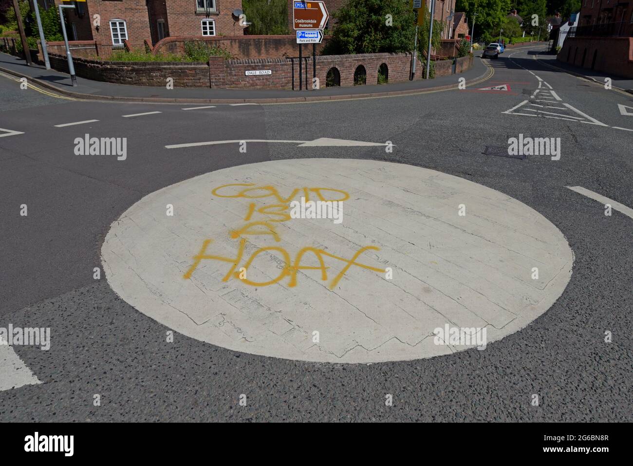 'Covid is a hoax' spray painted on a roundabout in Ironbridge, near Telford UK, by Covid deniers, June 2021 Stock Photo