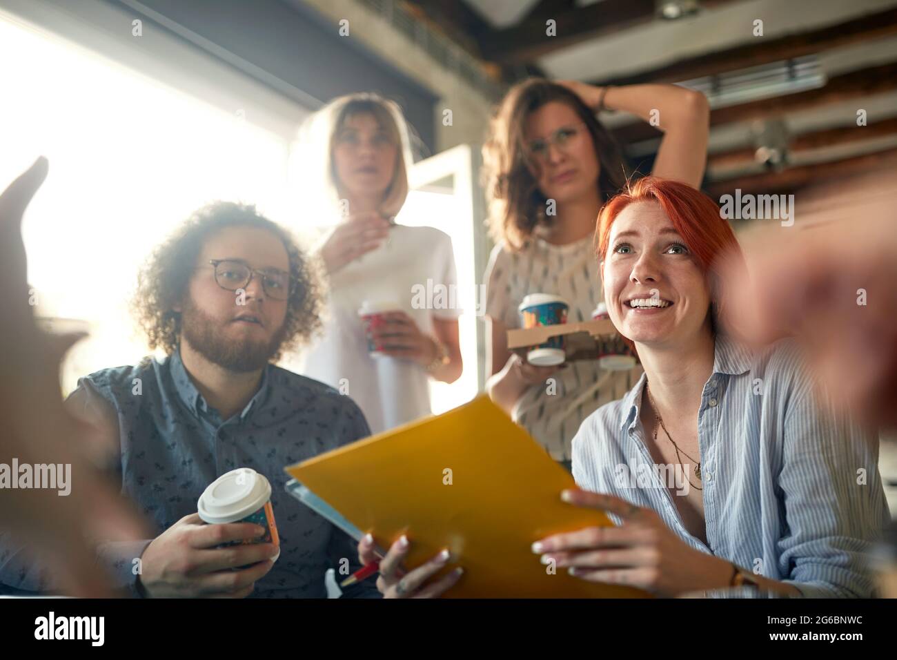 Group of young colleagues is worried about some job while working together in a tense atmosphere in the office Stock Photo