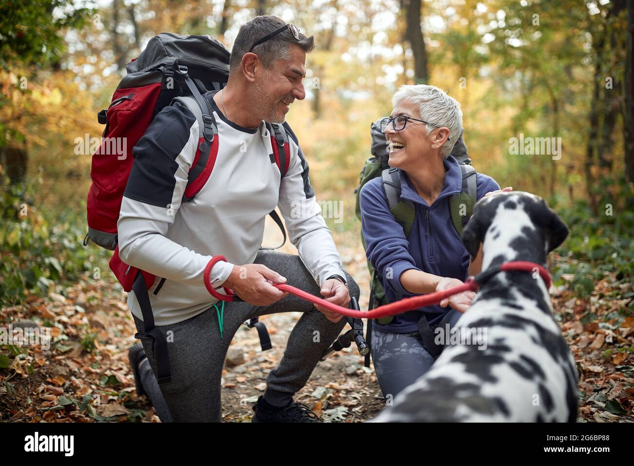 An elderly hikers couple and their dog enjoying a hike on a beautiful ...