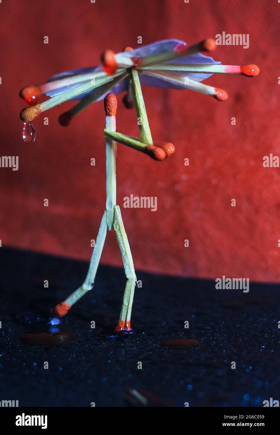 A matchstick man with a matchstick umbrella in the rain. Raining ...