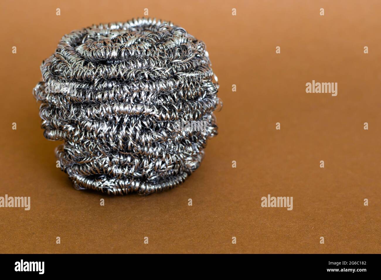 Stainless steel pot scrubber standout on brown background, copy space Stock  Photo - Alamy