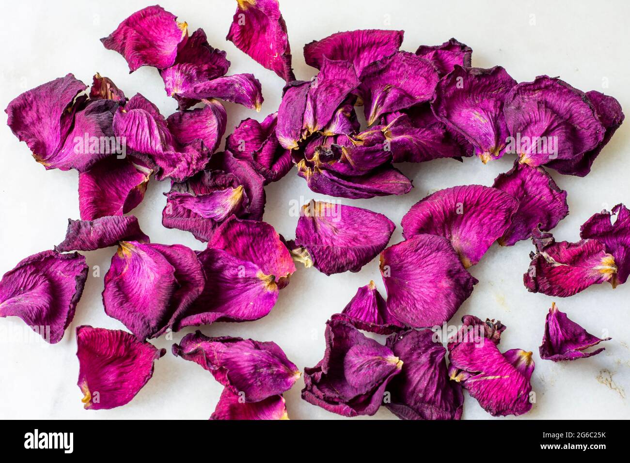 Top view of dried rose petals on marble background. Stock Photo