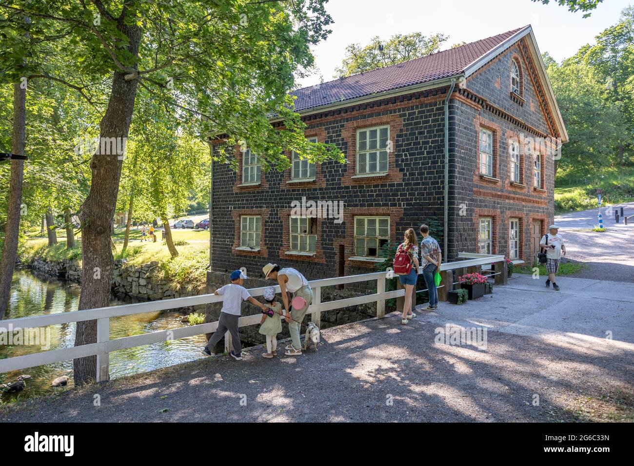People next to the Mill in Fiskars village, a historical ironworks area and popular travel destination. Stock Photo