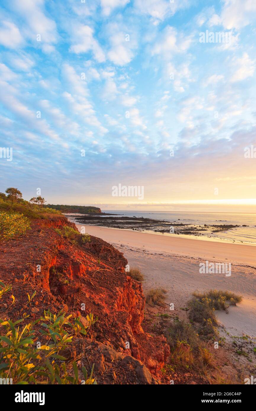 Vertical view of glowing red Pindan cliffs and pastel colours at sunrise on the beach, Pender Bay, Dampier Peninsula, Western Australia, WA, Australia Stock Photo