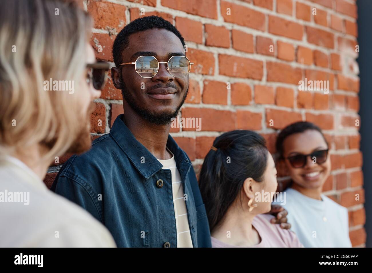 Diverse group of contemporary young people posing outdoors while ...