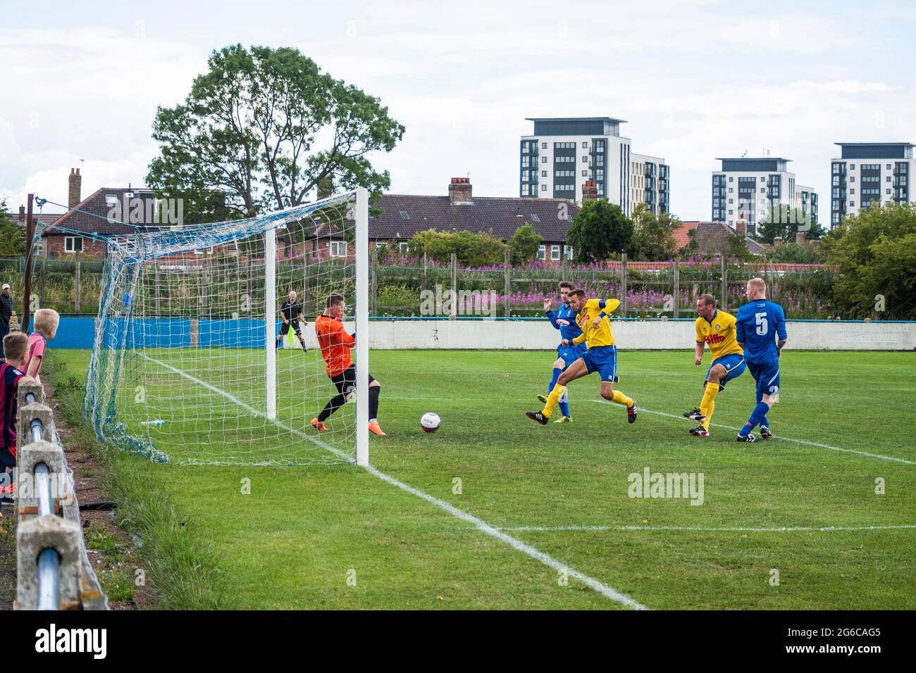 Local football match between Billingham and Stockton in north east England,UK.Forward strikes ball past keeper Stock Photo