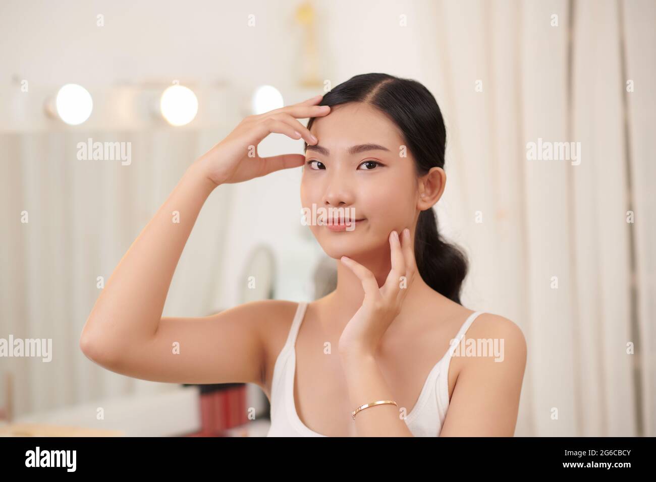 Perfect Skin. Cheerful Brunette Woman Touching Face Looking In Mirror Stock Photo