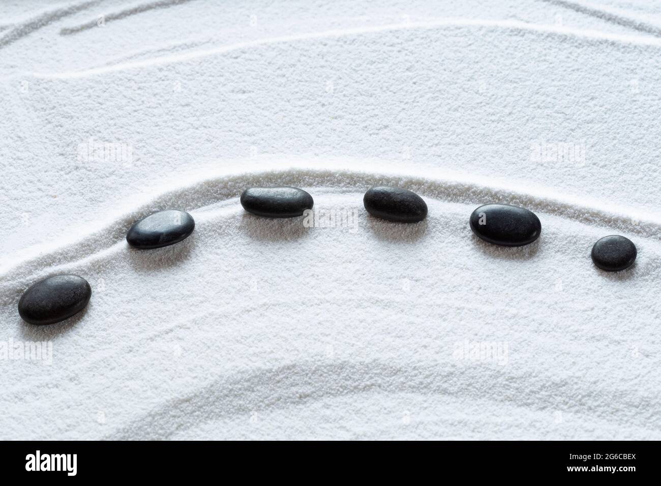 Zen black pebbles on white sand Stock Photo