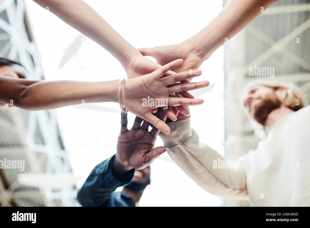Low angle close up of multi-ethnic group of young people stacking hands ...
