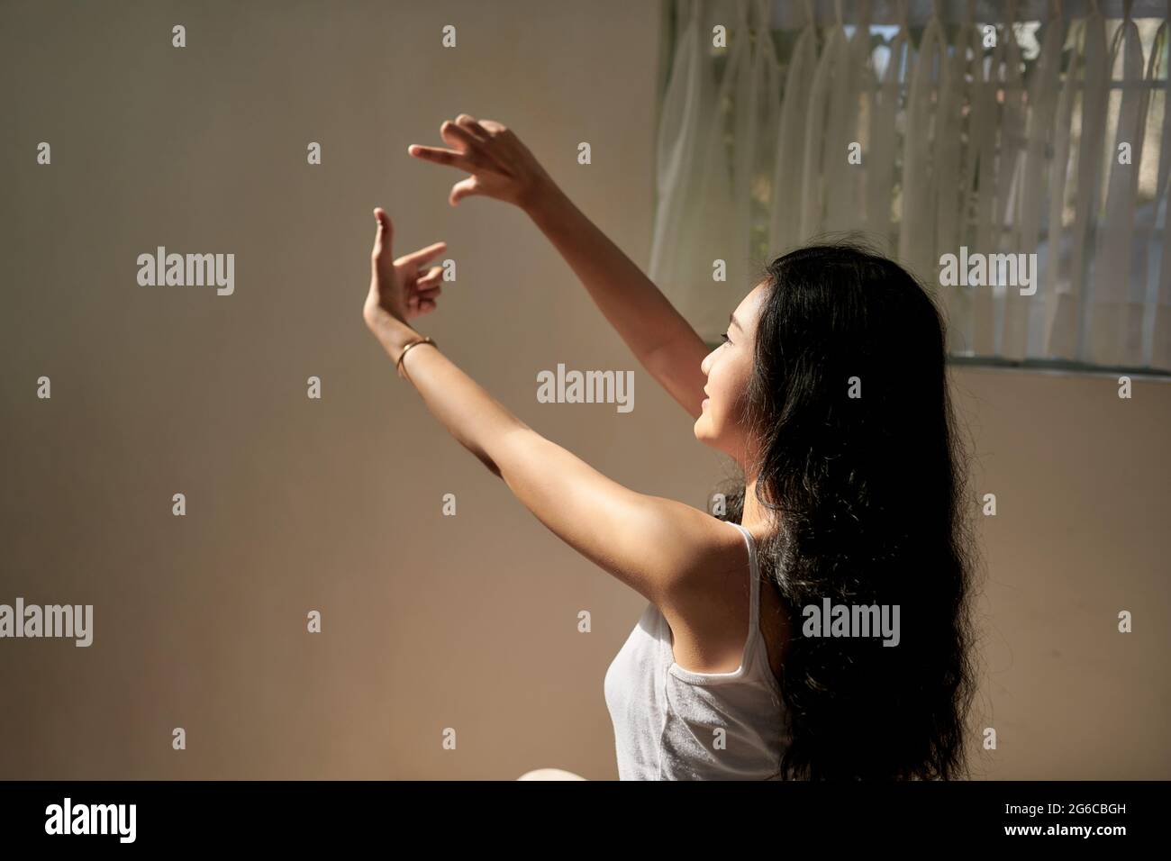 happy Asian girl in pajamas on weekend in sun glow Stock Photo