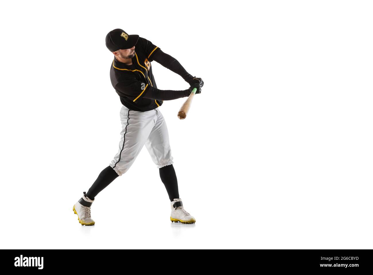 Baseball player, pitcher in a black white sports uniform practicing isolated on a white studio background. Stock Photo