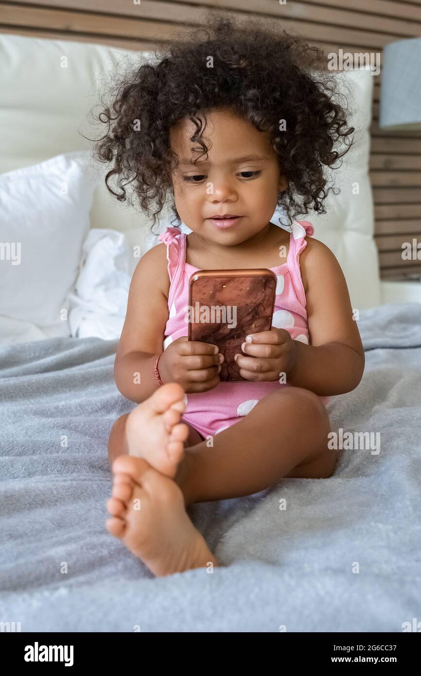Vertical portrait of african american girl little child using smartphone Stock Photo