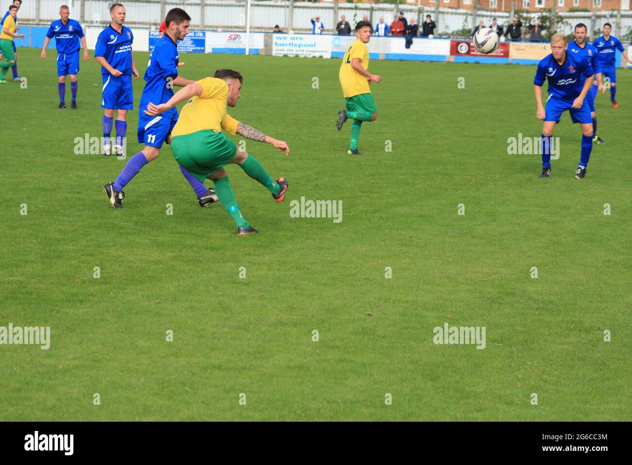 Local football match between Billingham and Stockton in north east England,UK. Defender clears ball upfield. Stock Photo