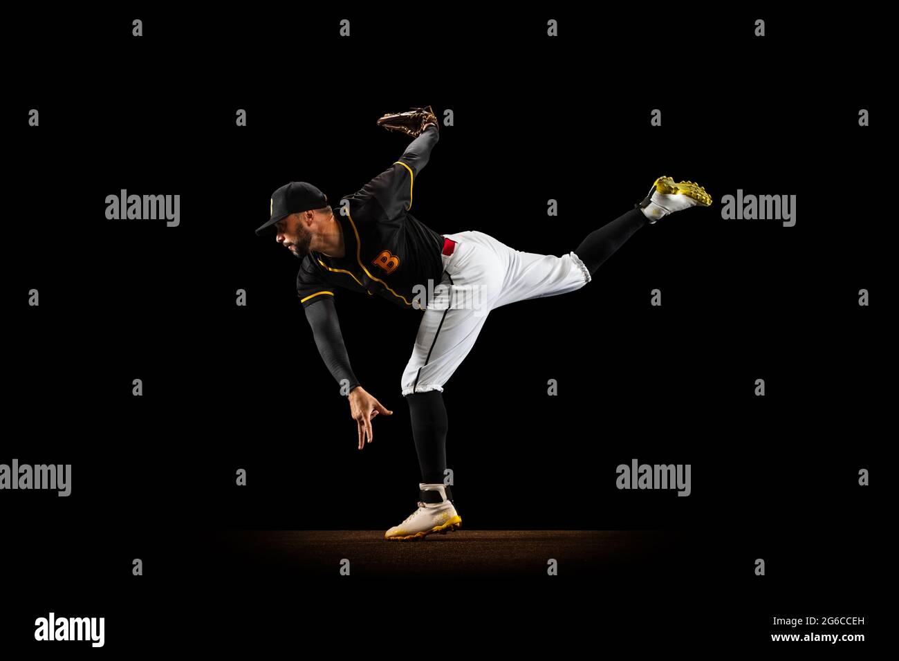 Professional baseball player, pitcher in sports uniform and equipment practicing isolated on a black studio background. Team sport concept Stock Photo