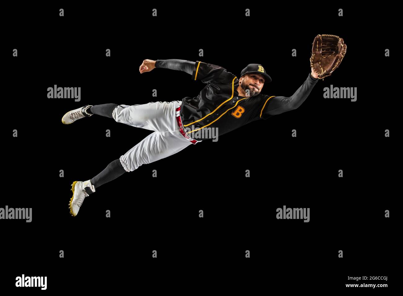 Flying. Baseball player, catcher in sports uniform and equipment practicing isolated on a black studio background. Team sport concept Stock Photo