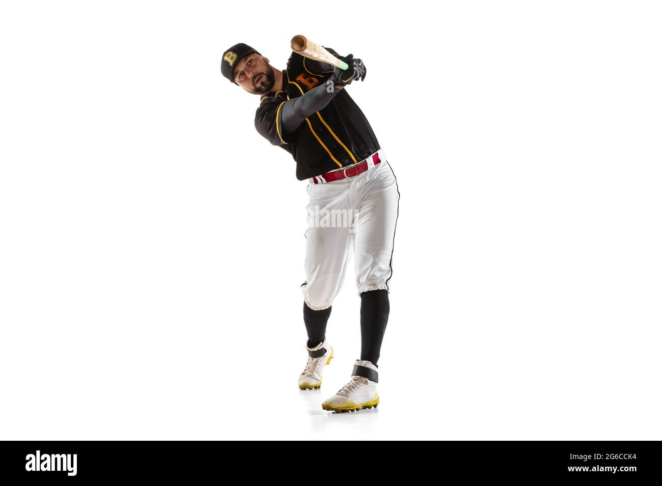 Baseball player, pitcher in a black white sports uniform practicing isolated on a white studio background. Stock Photo