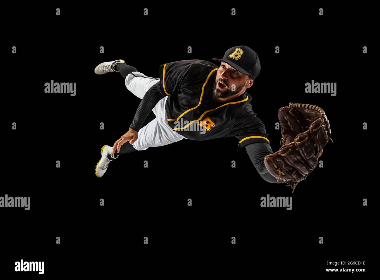 Flying. Baseball player, catcher in sports uniform and equipment practicing isolated on a black studio background. Team sport concept Stock Photo