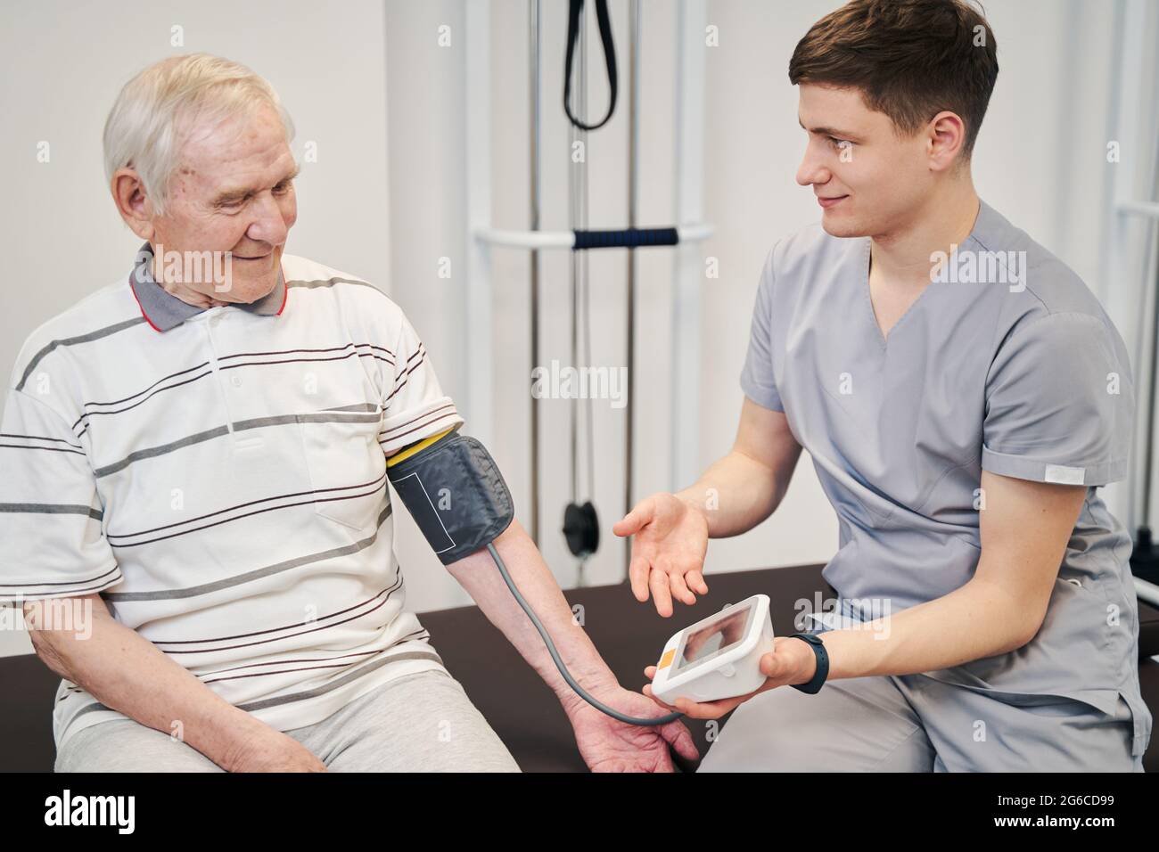 Young medical specialist showing pensioner his pressure results Stock Photo