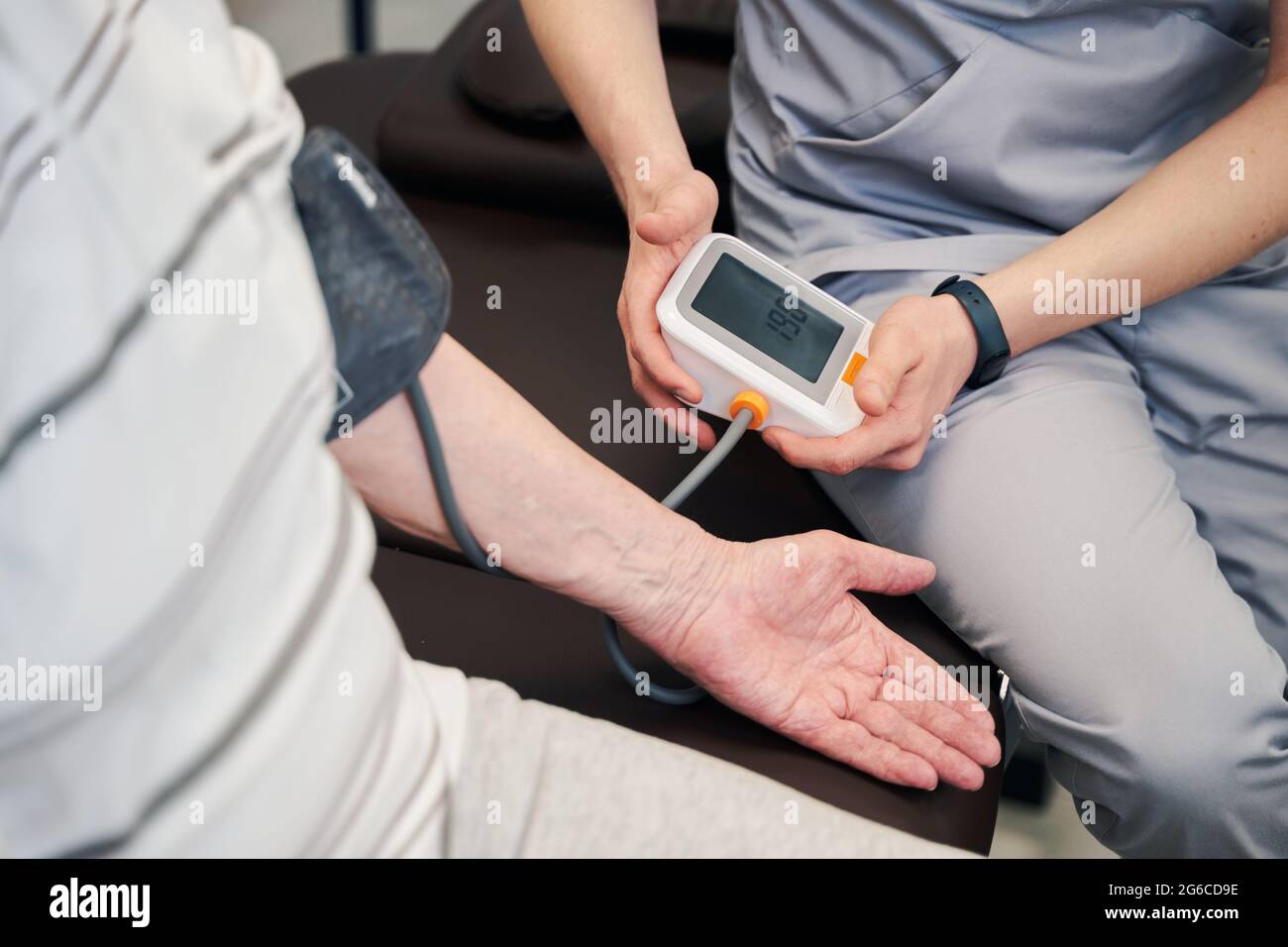 Medical worker using blood pressure monitor on pensioner Stock Photo