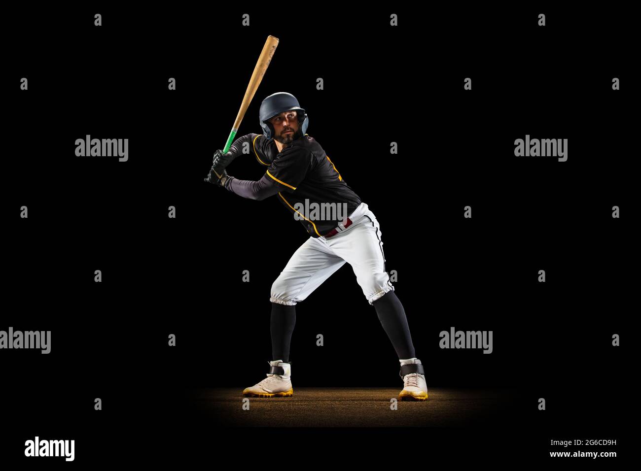 Professional baseball player, pitcher in sports uniform and equipment practicing isolated on a black studio background. Team sport concept Stock Photo