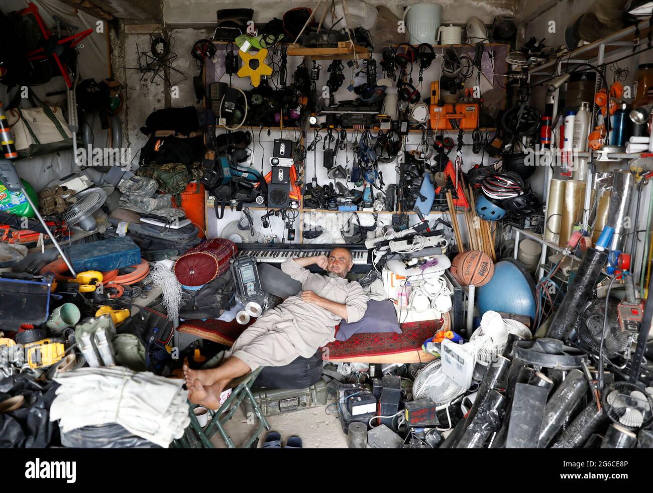 An Afghan man rests in his shop as he sell U.S. second hand materials  outside Bagram U.S. air base, after American troops vacated it, in Parwan  province, Afghanistan July 5, 2021. REUTERS/Mohammad