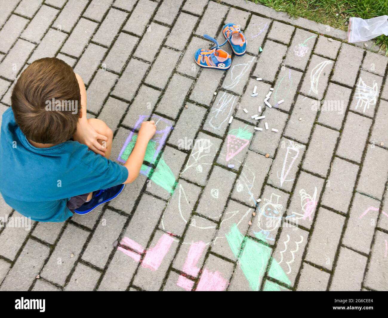 Little child drawing with chalk on asphalt Stock Photo - Alamy