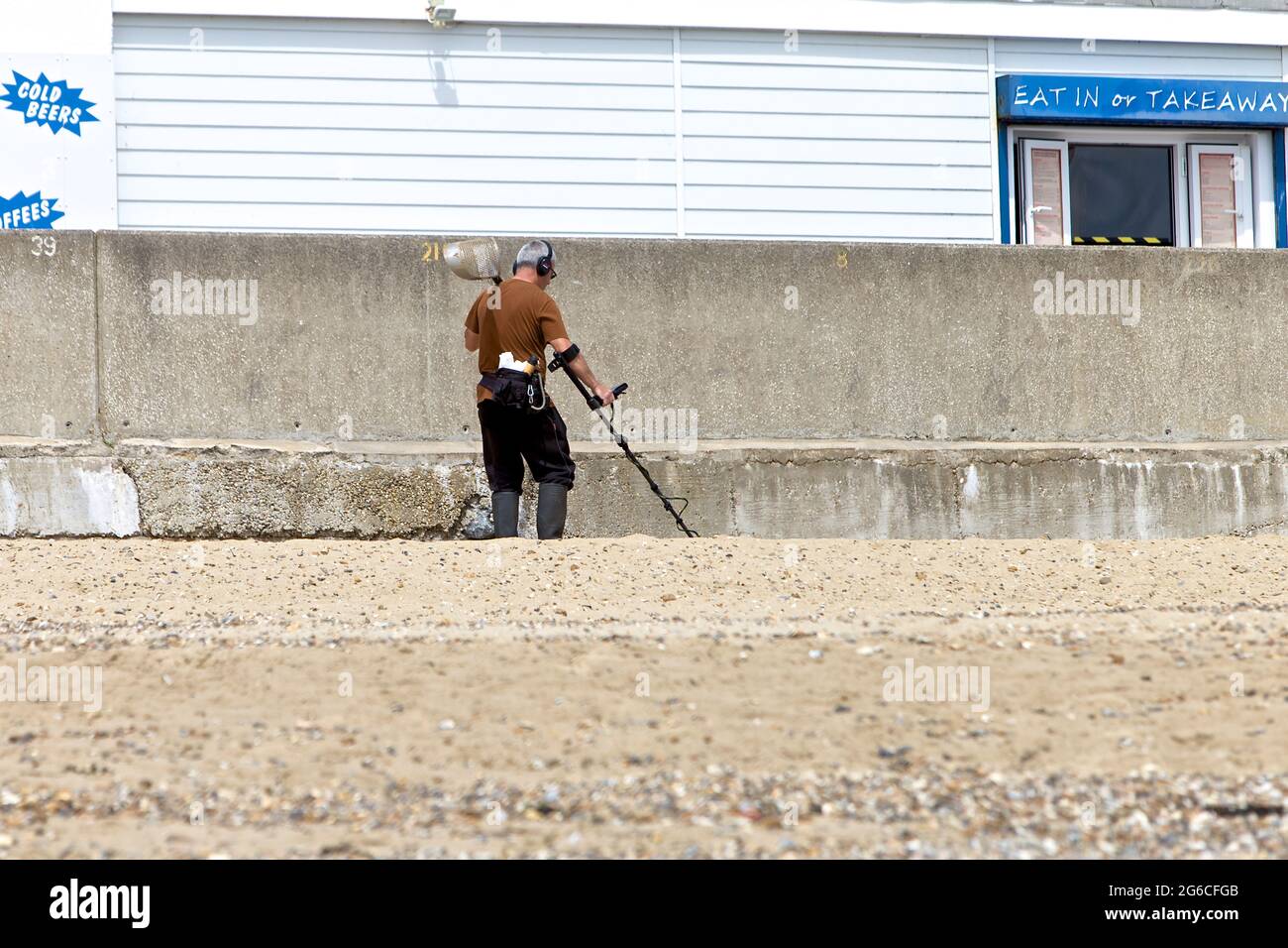 Metal Detectorist scanning the beach for valuables at Holland on Sea Essex Stock Photo Alamy