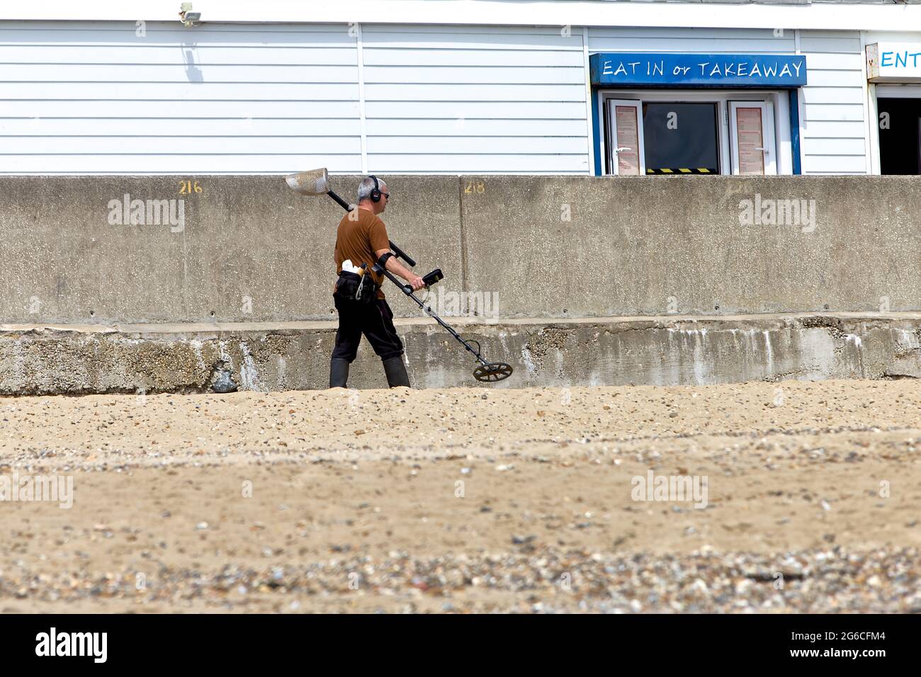 Metal Detectorist scanning the beach for valuables at Holland on Sea Essex Stock Photo Alamy