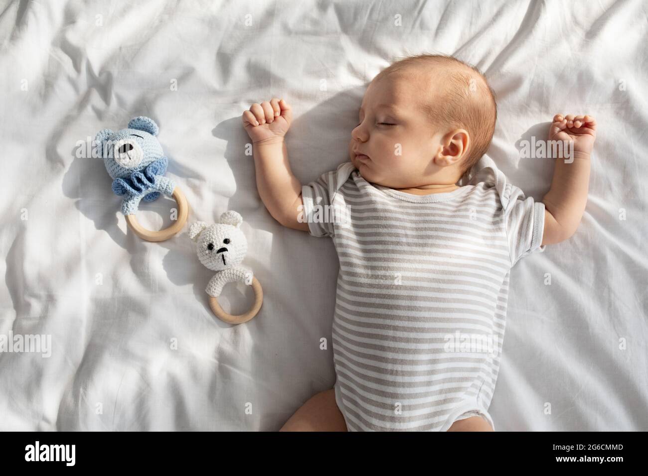 Sweet Cute Adorable Newborn Baby Sleeping On Bed Next To Rattle Toys Stock Photo Alamy