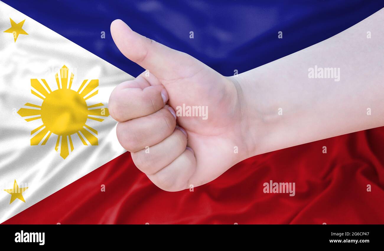 Hand makes a thumbs up sign on the background of the flag of ...