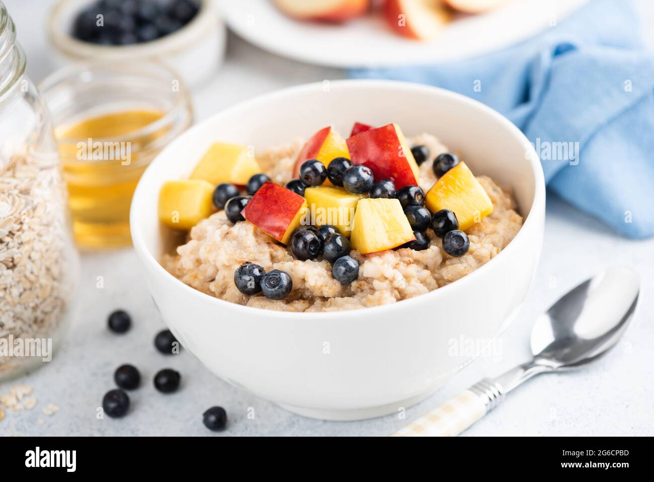 Healthy vegetarian breakfast food oatmeal porridge with fruits and honey. Weight loss, clean eating lifestyle concept Stock Photo