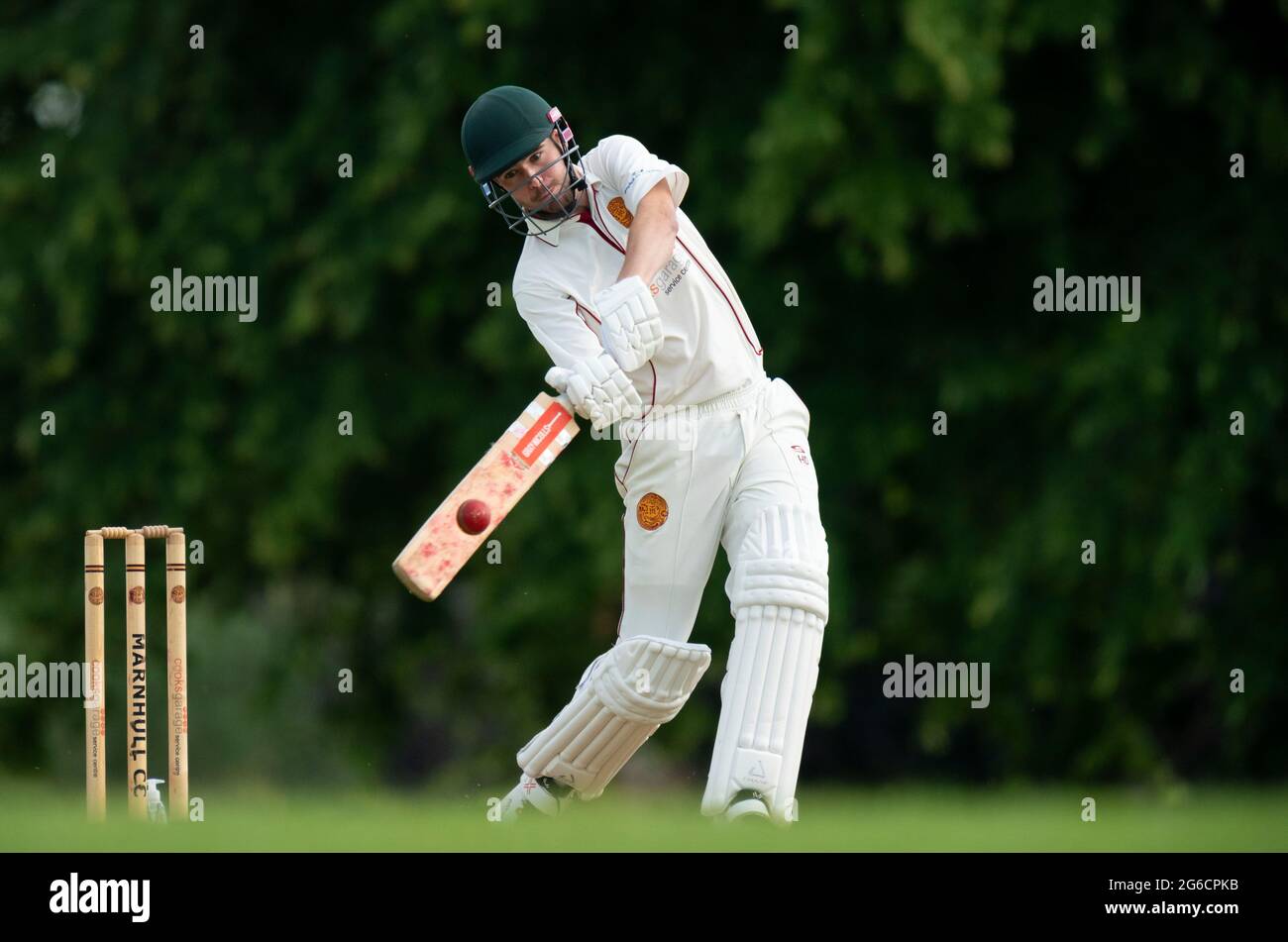 Cricket batsman hitting four runs. Stock Photo