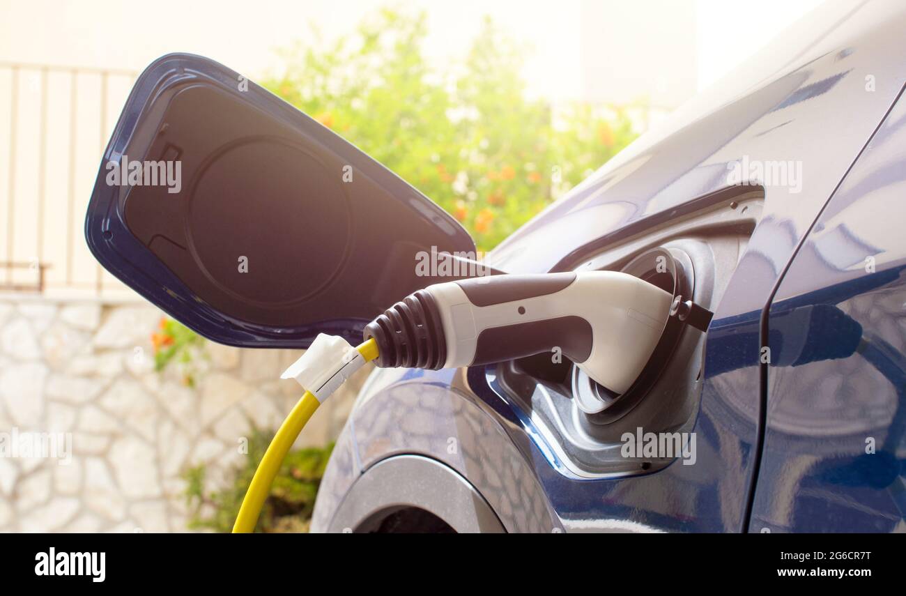 The electric car charger plugged in to the socket.The modern electric