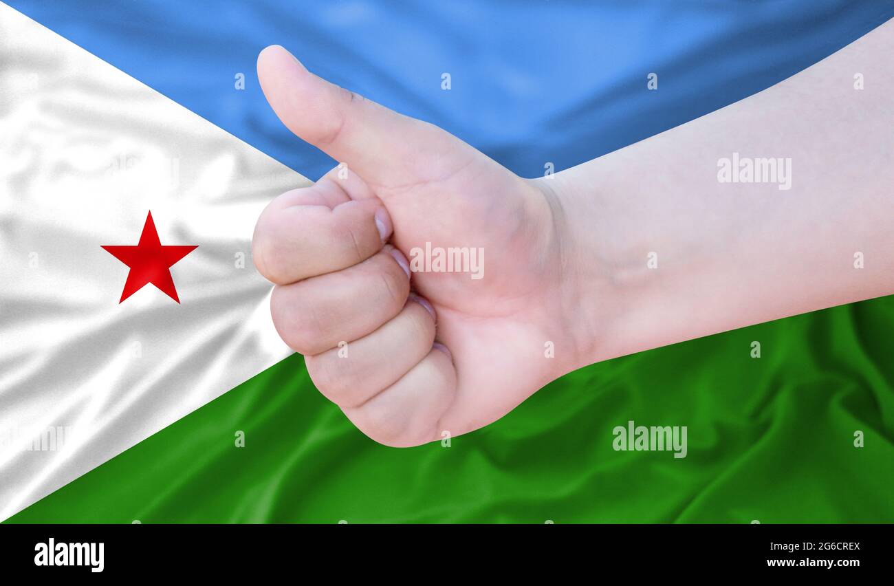Hand makes a thumbs up sign on the background of the flag of Djibouti. like, good, positive Stock Photo