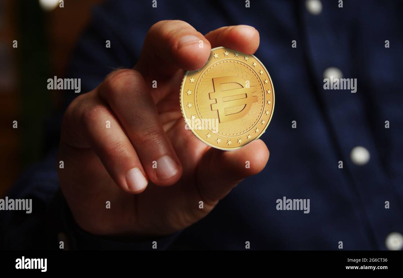 Dai stablecoin cryptocurrency symbol golden coin in hand abstract concept. Stock Photo