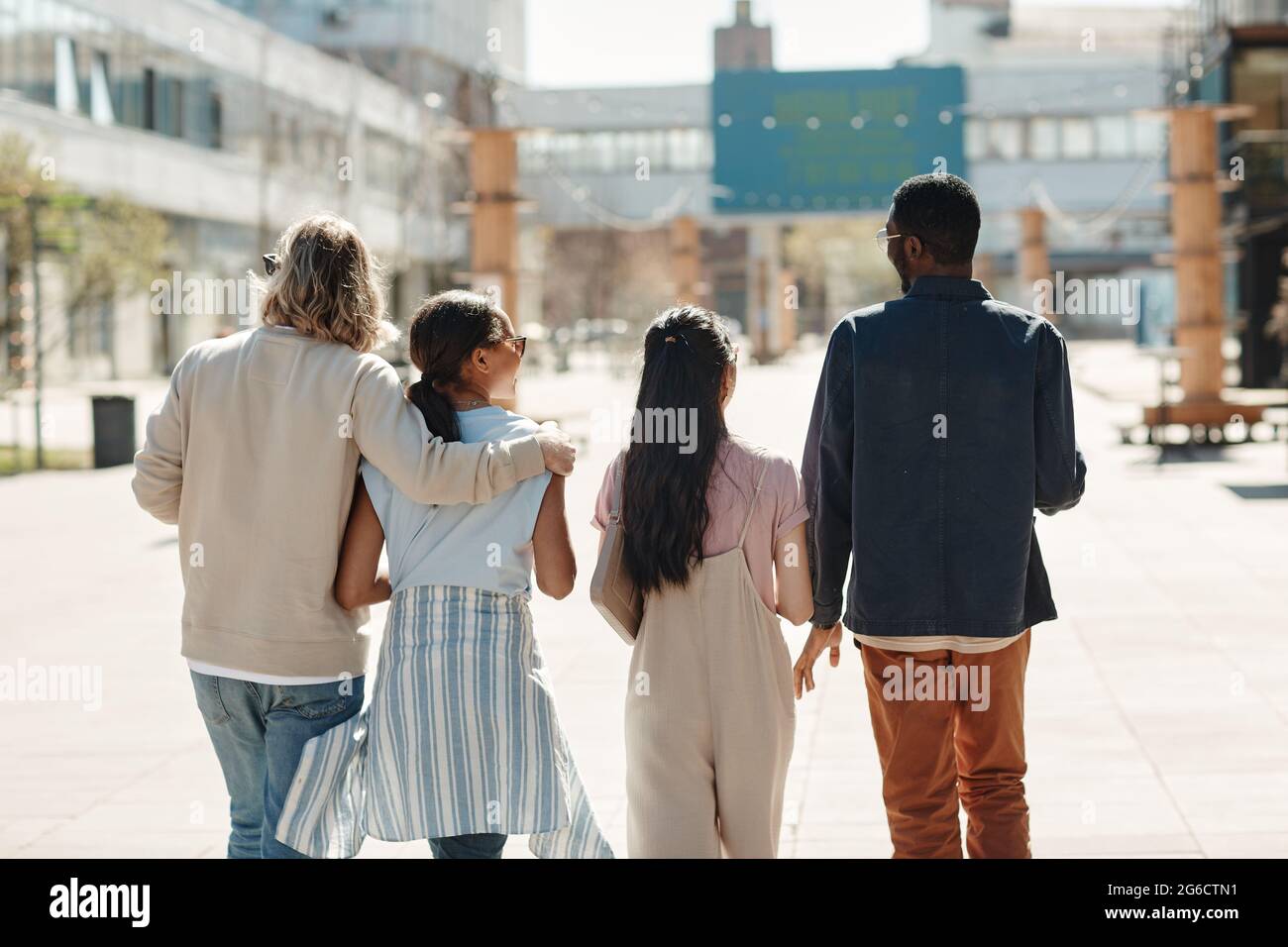 Back view at diverse group of young people walking in city Stock Photo ...
