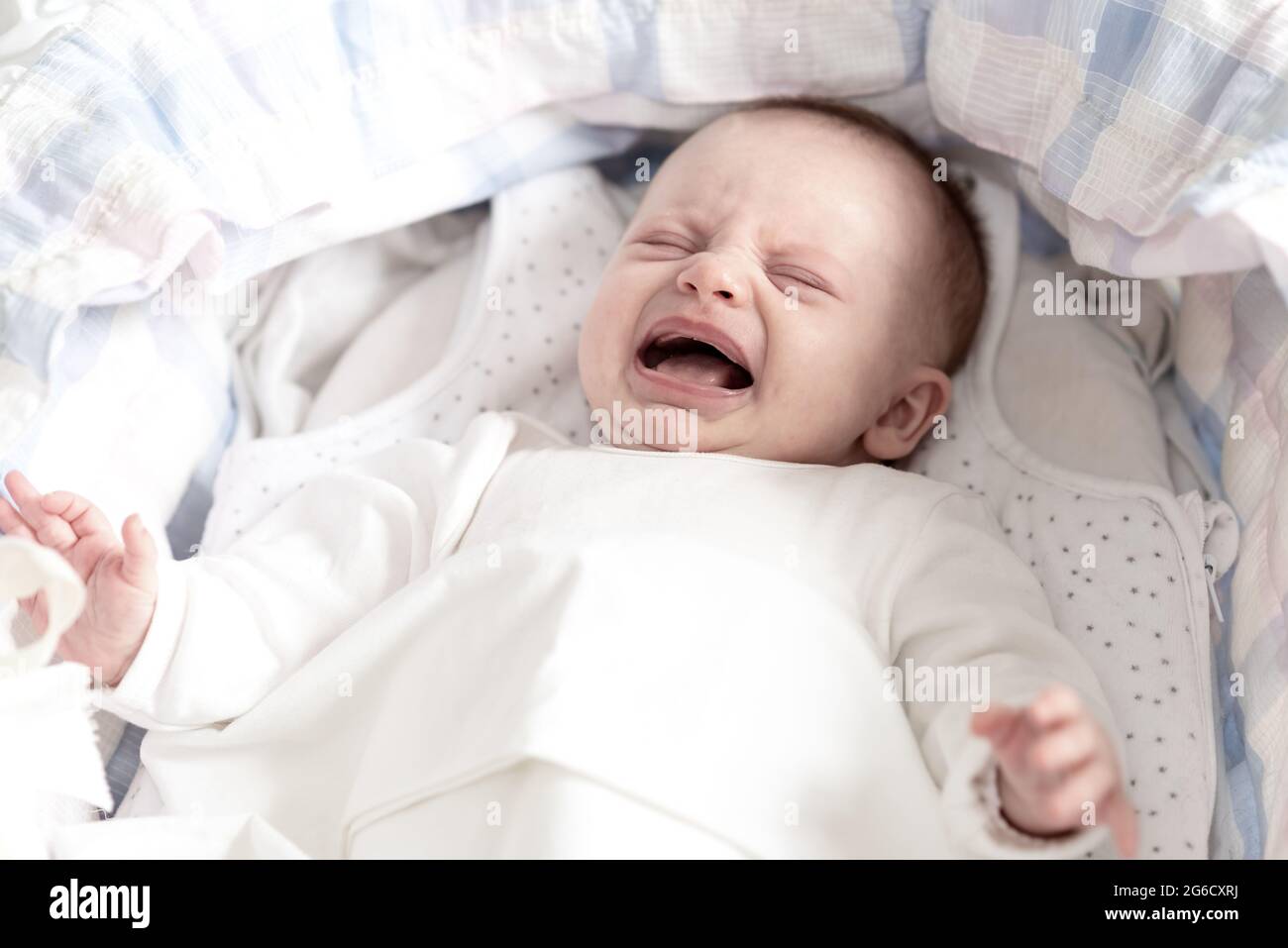 Little baby girl crying in her crib Stock Photo Alamy