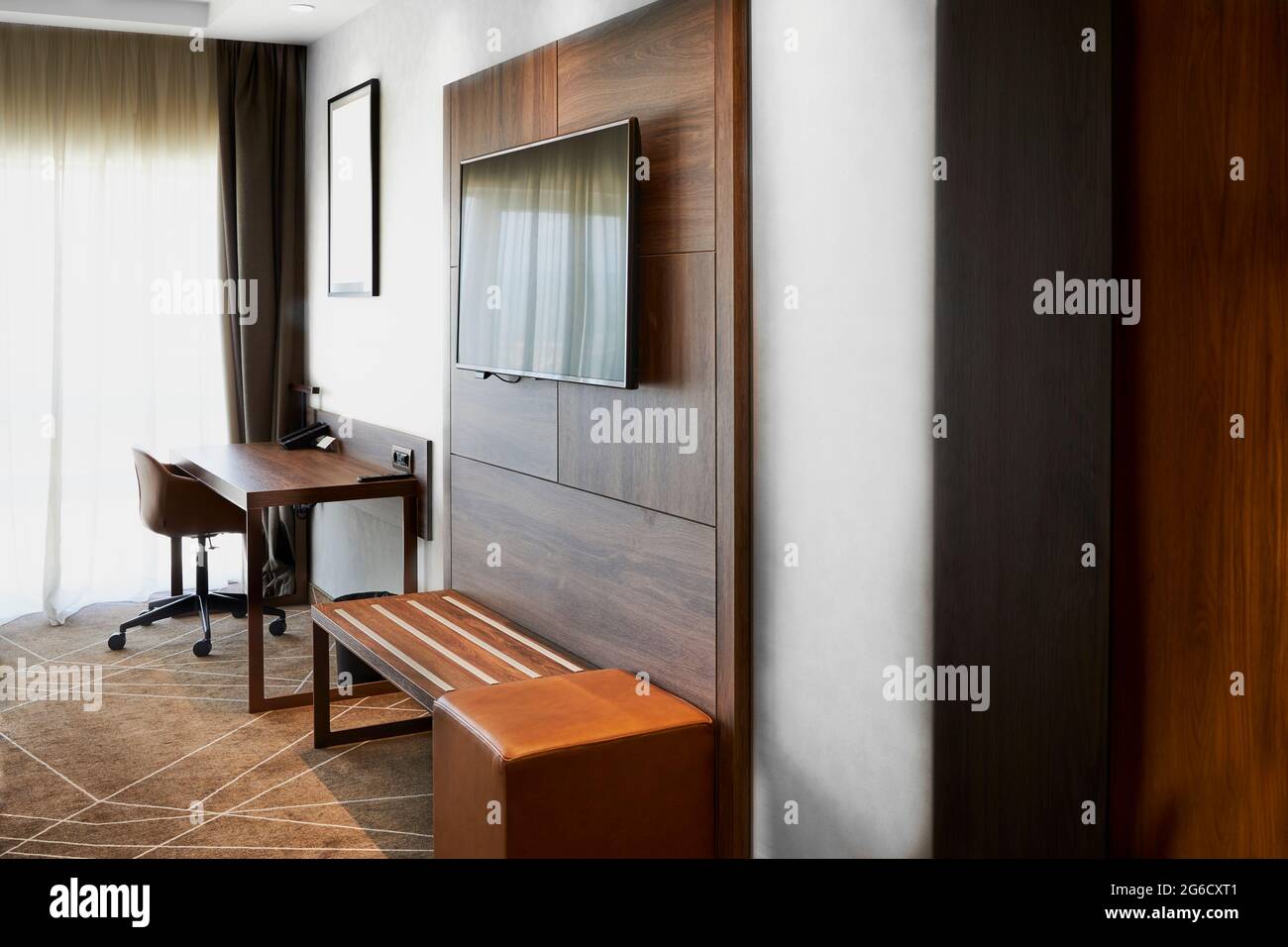 Interior of a hotel room with a TV set and a work table Stock Photo