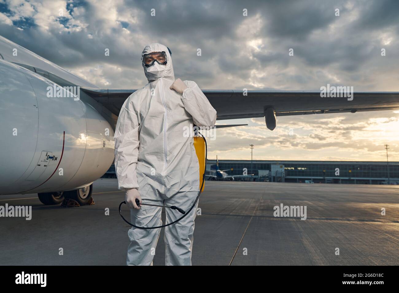 Man in a hazmat suit standing at the airdrome Stock Photo