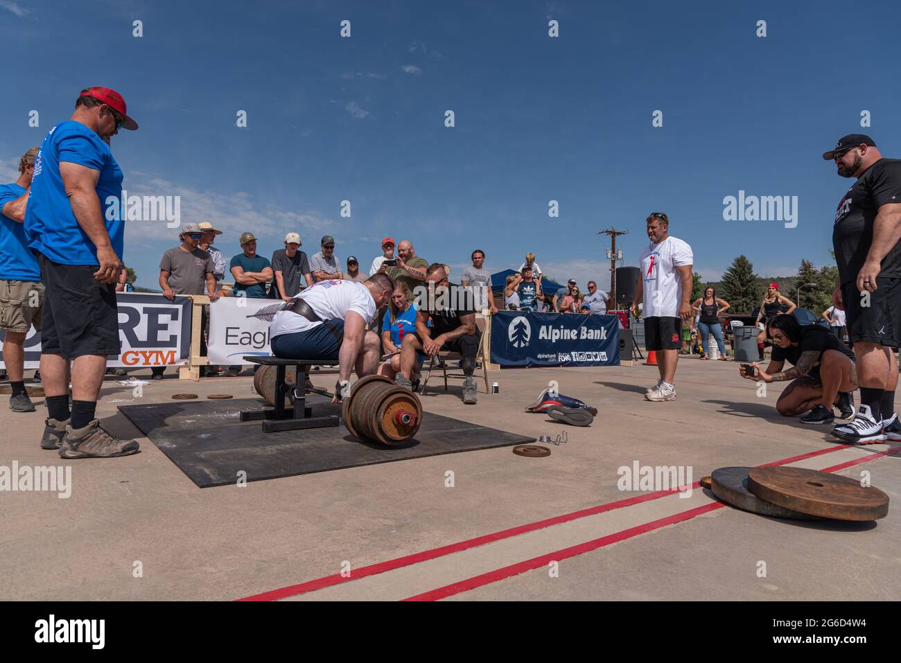 Athlete with disability surrounded by supporters, judges and spotters prepares to lift a loaded barbell in the Crown Mountain Strongman Championship . Stock Photo
