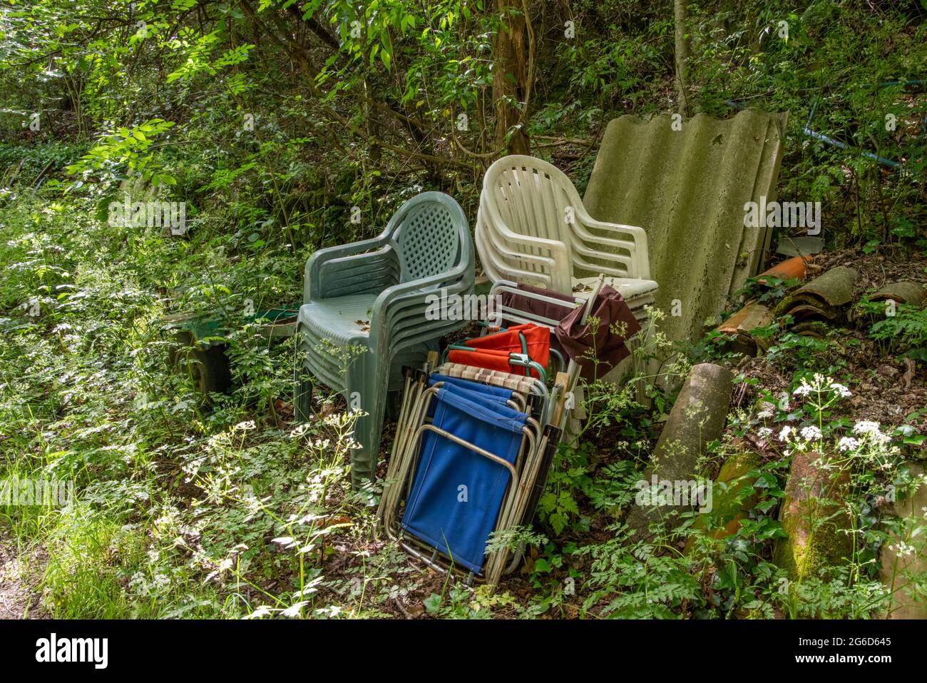Wild garbage dump, chairs and roofing, in the middle of nature Stock