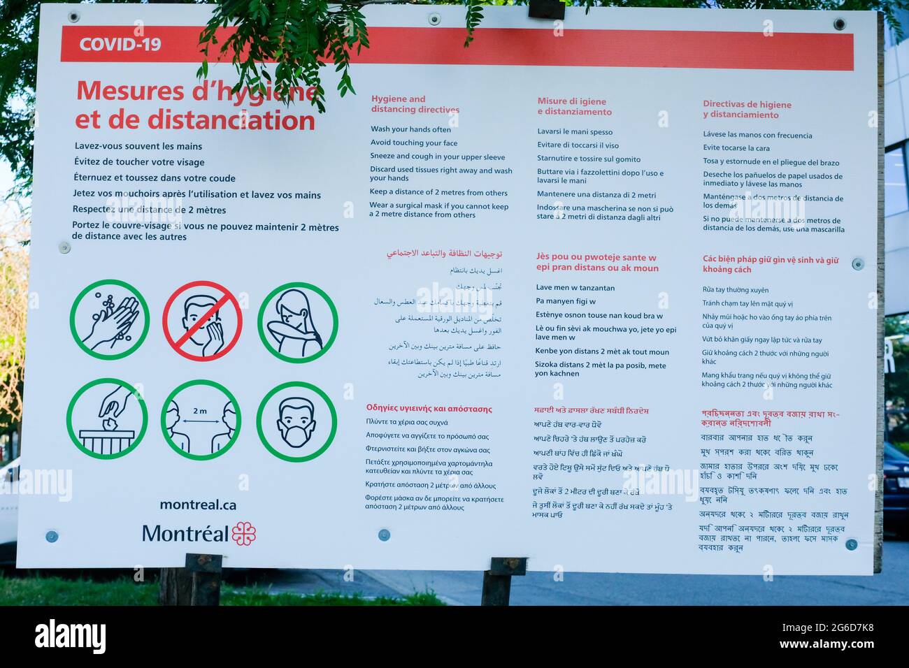 Covid Prevention billboard in many languages, Montreal Canada Stock Photo